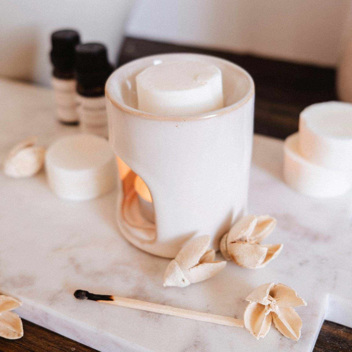 White ceramic diffuser with floral designs on a marble surface