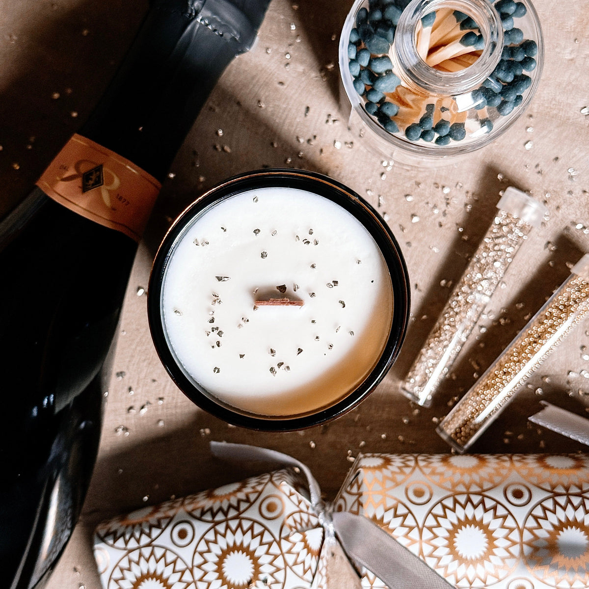 Candle, bottle, and decorative items on a textured surface