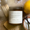 Coastal Cove Candle Co. Lemon Shortbread candle with cookies and a lemon on a textured surface
