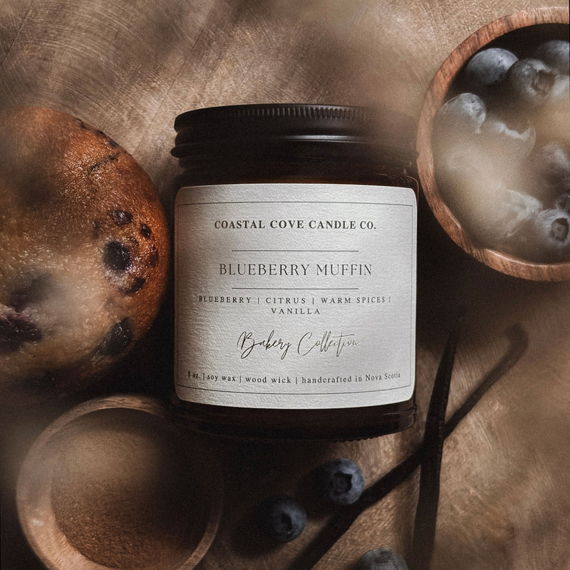 Coastal Cove Candle Co. Blueberry Muffin candle with natural elements on a textured surface