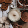 Candle with pecans and fudge on a textured surface