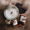 Candle with marshmallows and graham crackers on a textured surface