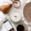 Candle, jar of ground cloves, and other kitchen items on a light surface