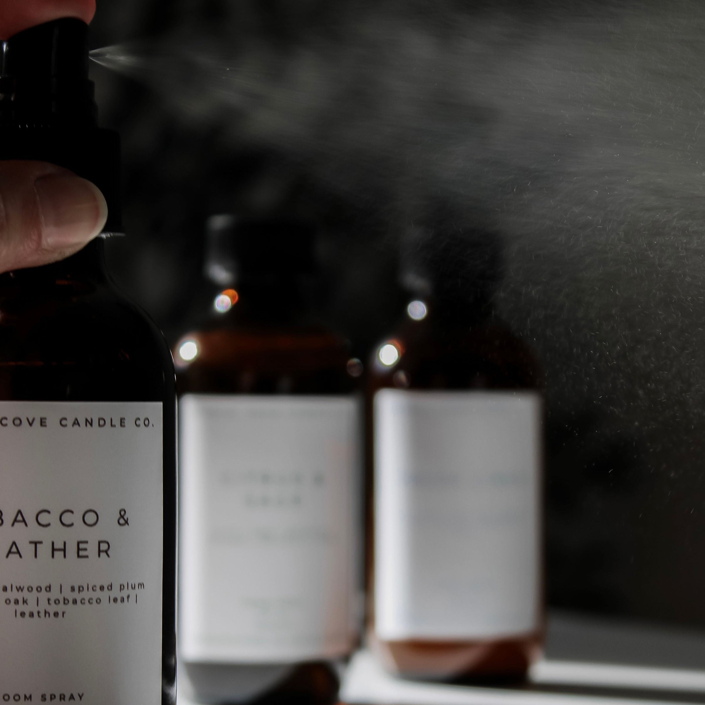 Room spray bottles with labels on a reflective surface