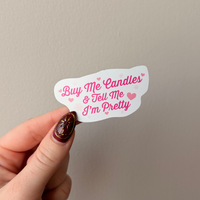 Hand holding a sticker with text against a plain background